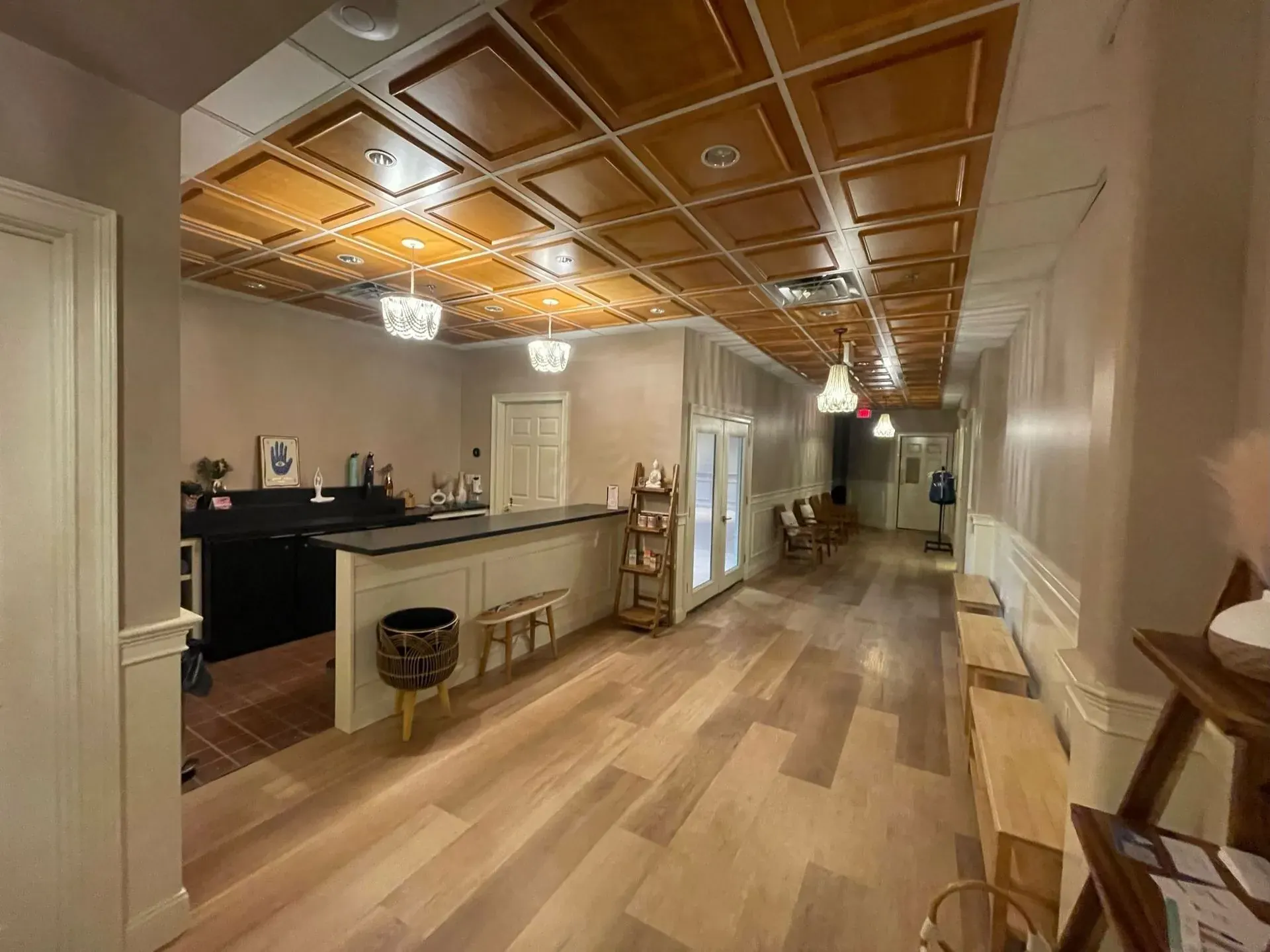 Hallway with a wood coffered ceiling and small pendants