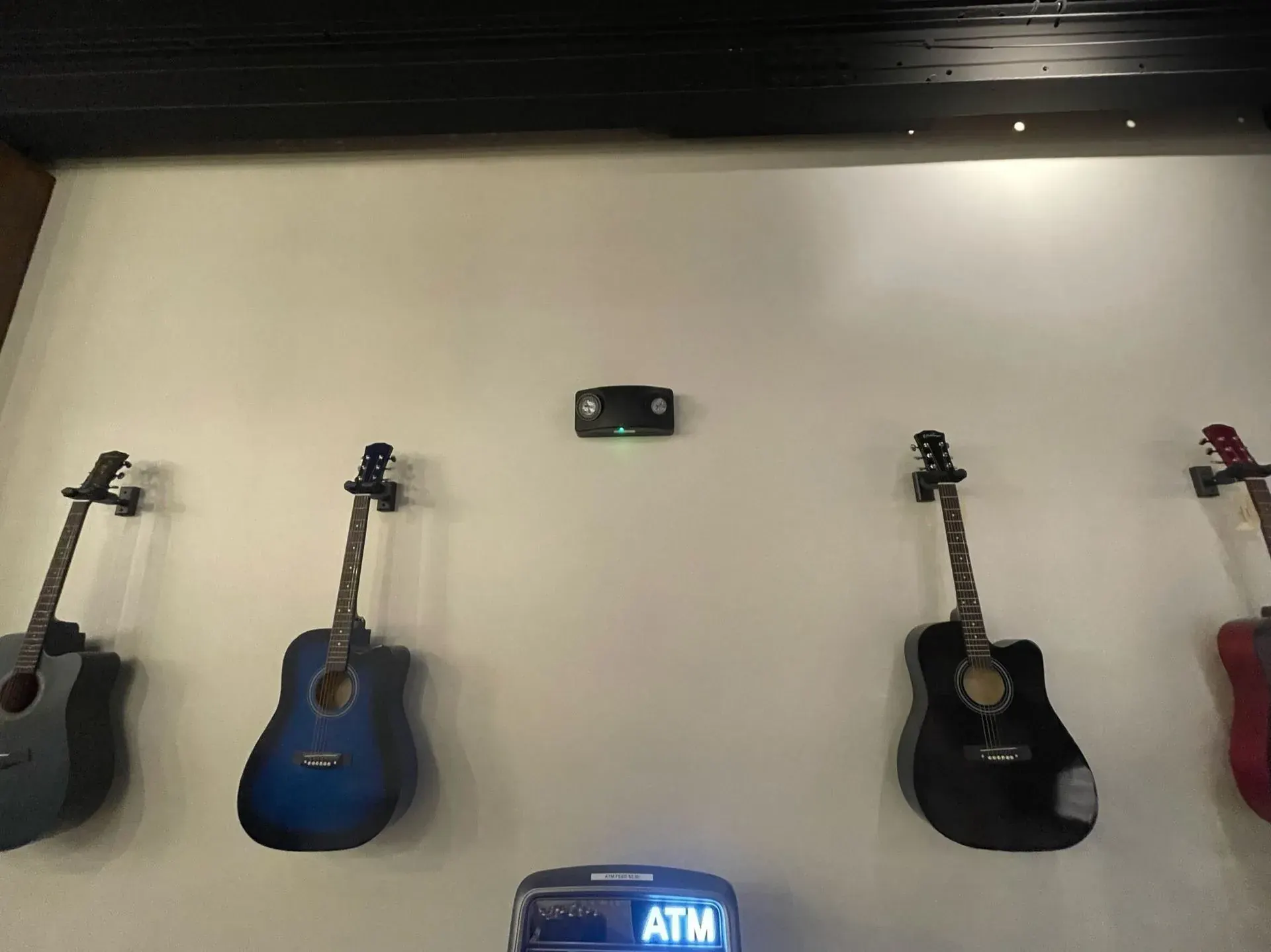 Guitars hanging on a display wall lit from above