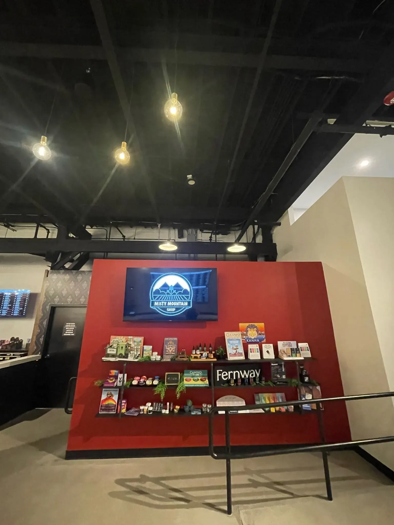 Red retail display wall with a TV and spot lighting