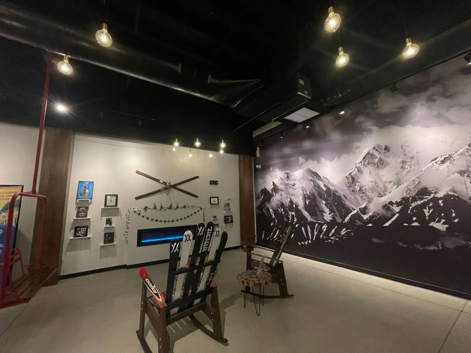 Mountain mural wall lit by track heads in a retail space
