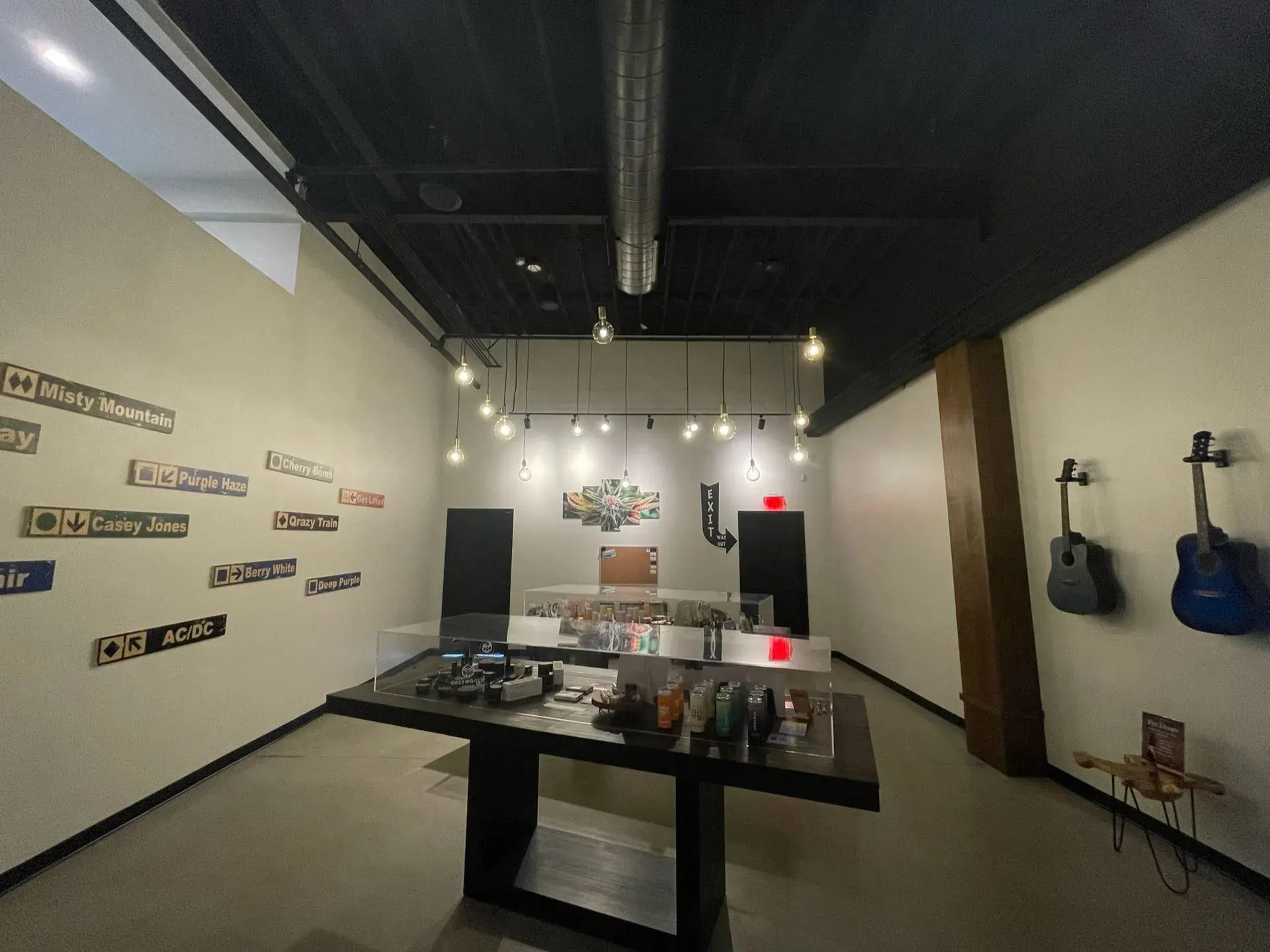 Retail shop floor lit by bare-bulb pendants and wall displays