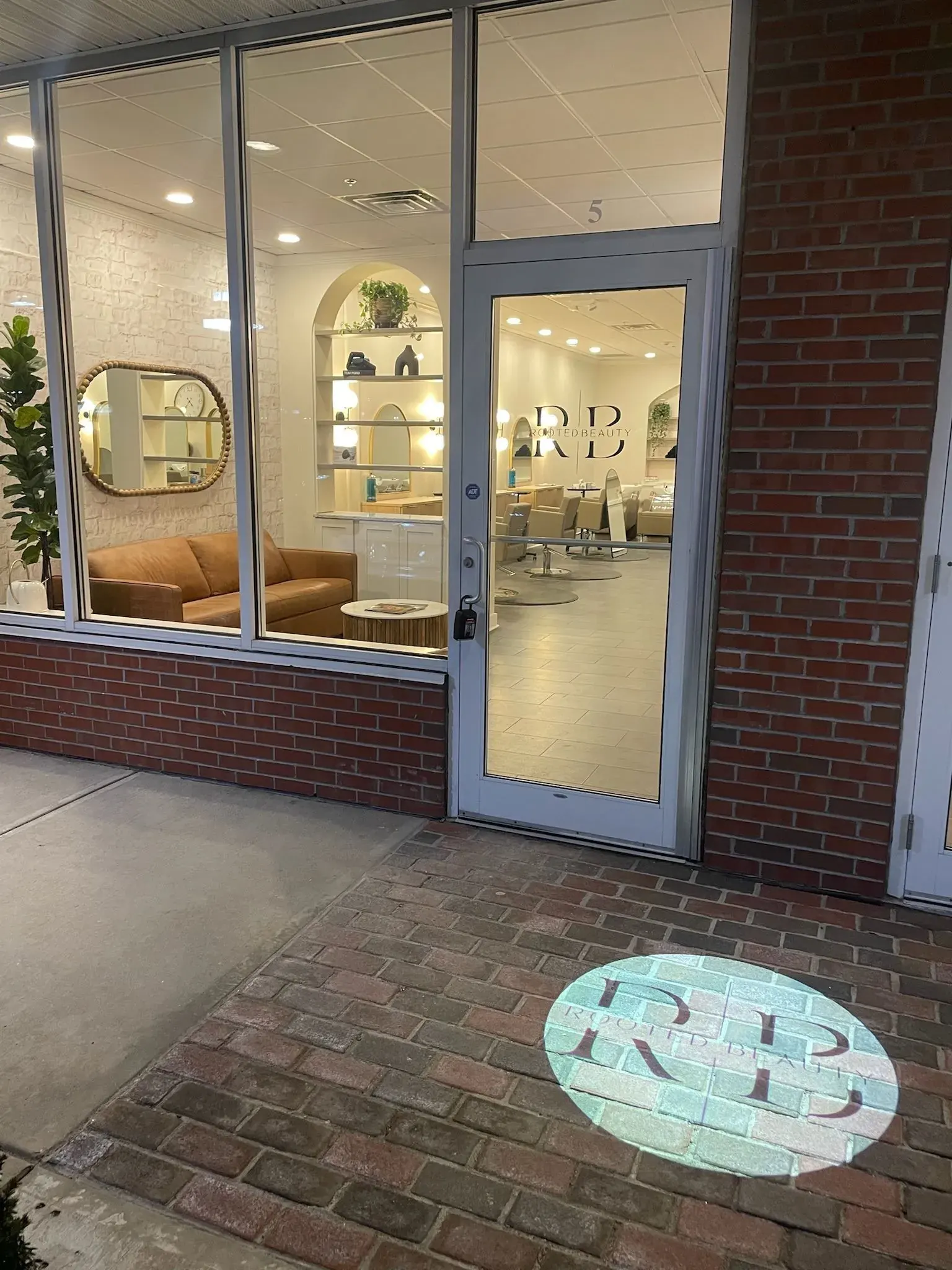 Salon entrance with a logo projected onto the brick walkway