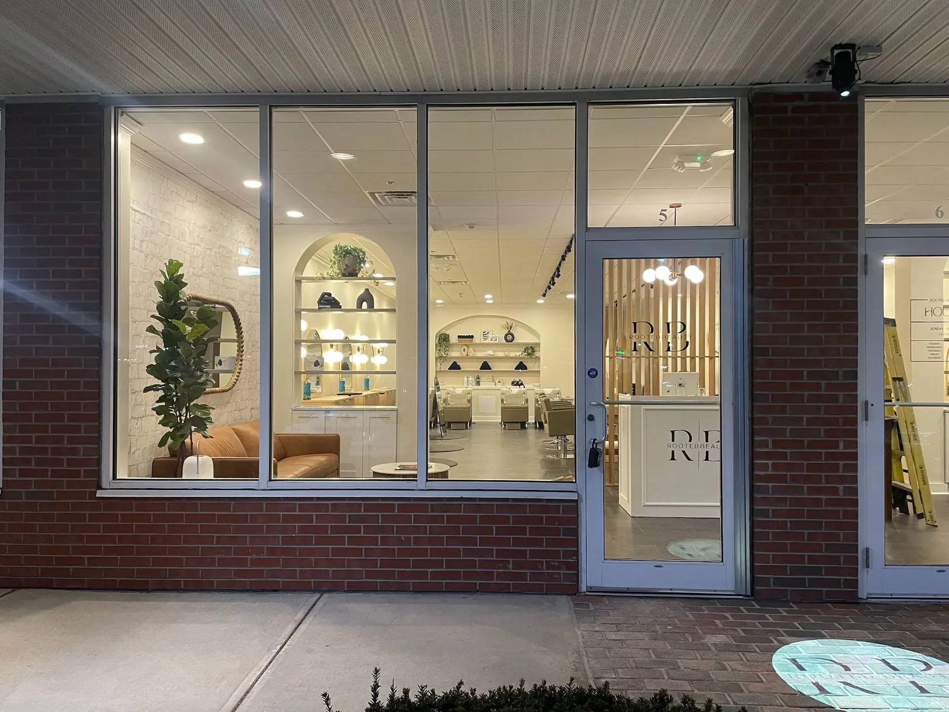 Salon storefront windows showing the lit interior