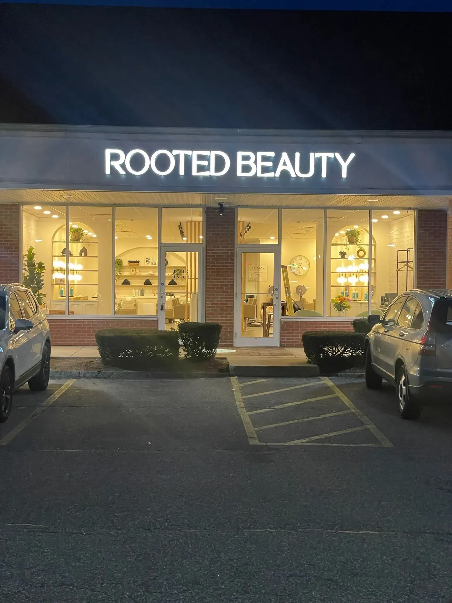 Salon storefront with an illuminated sign at night
