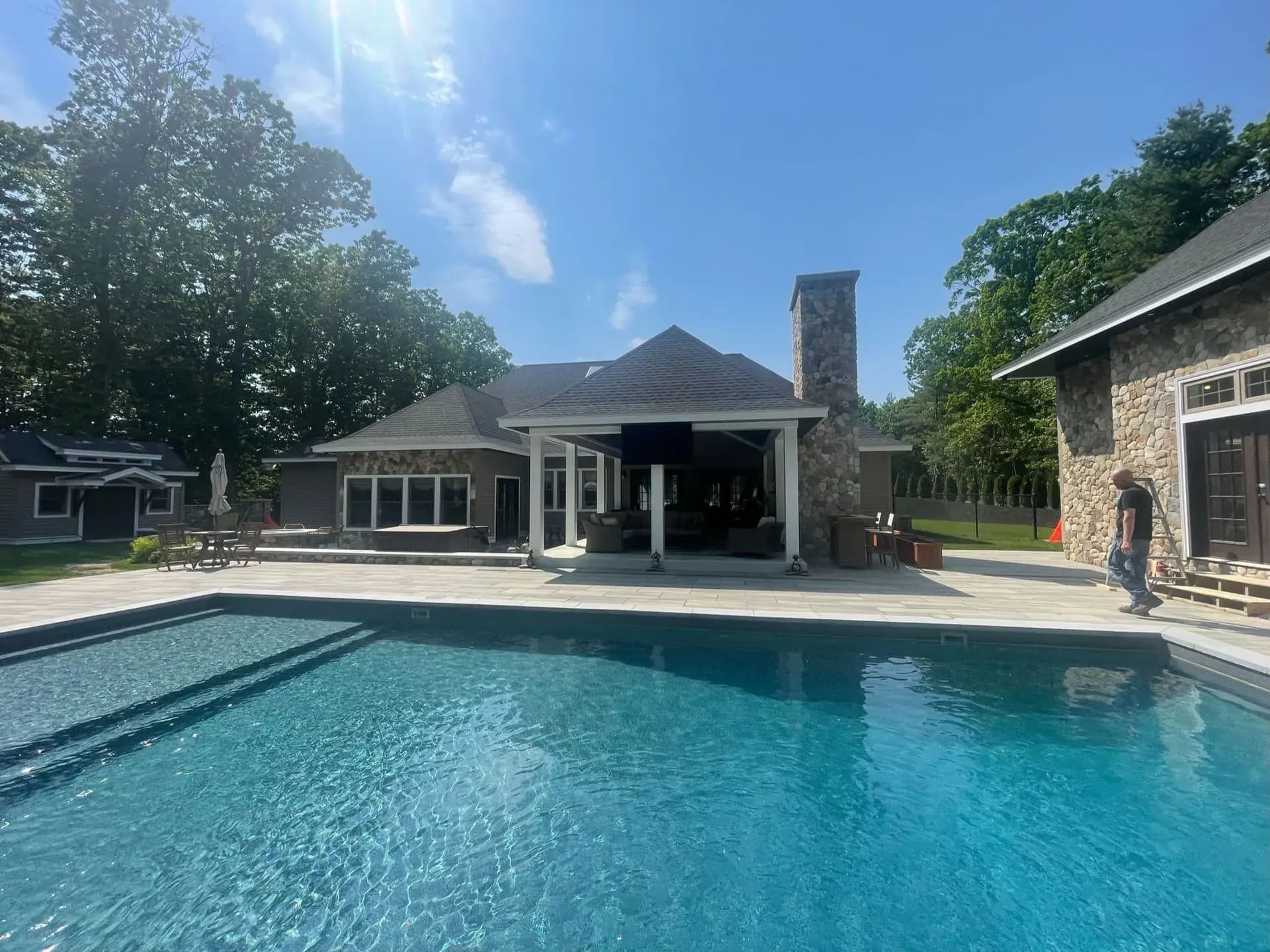 Backyard pool with a pavilion and stone chimney