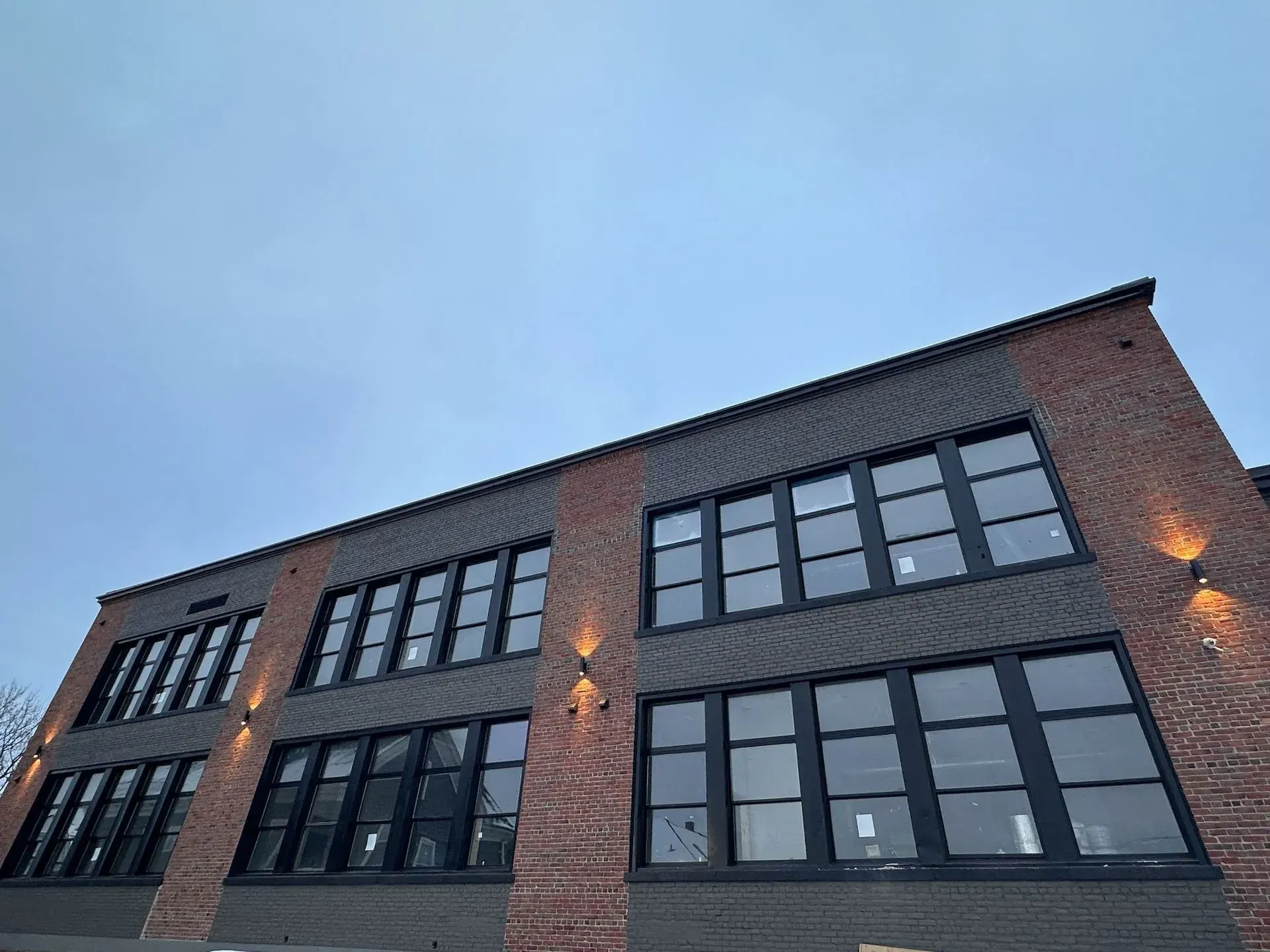 Brick mill-style building with up-and-down wall sconces