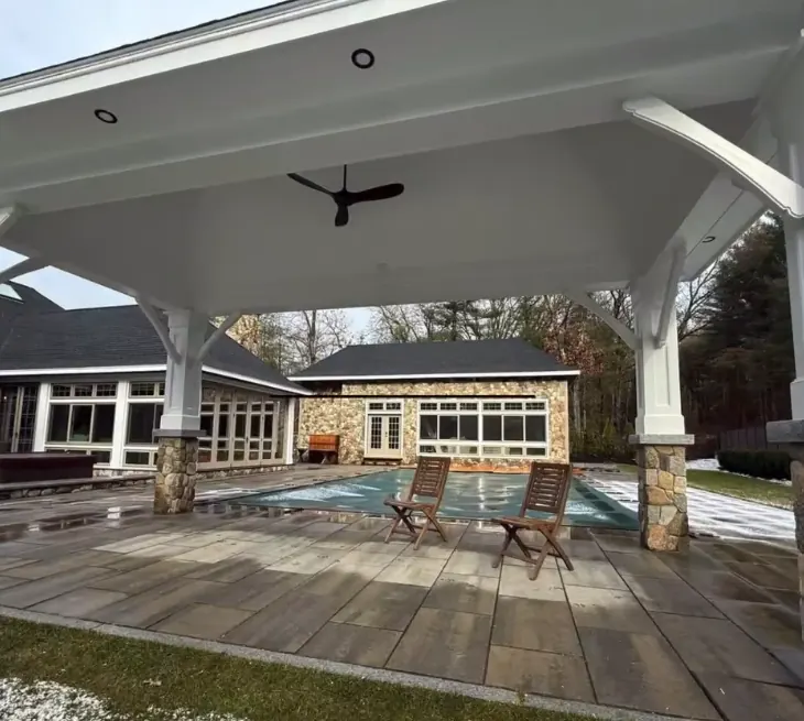 Poolside cabana with an outdoor ceiling fan and recessed soffit lights