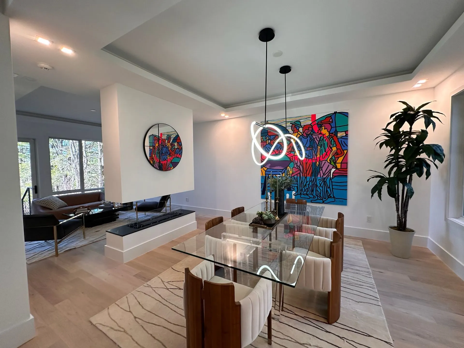Dining room under a tray ceiling with sculptural pendant lights