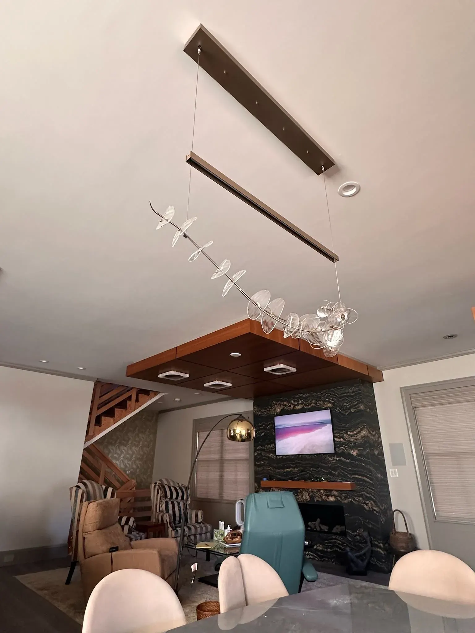 Linear pendant over a dining table near a fireplace wall