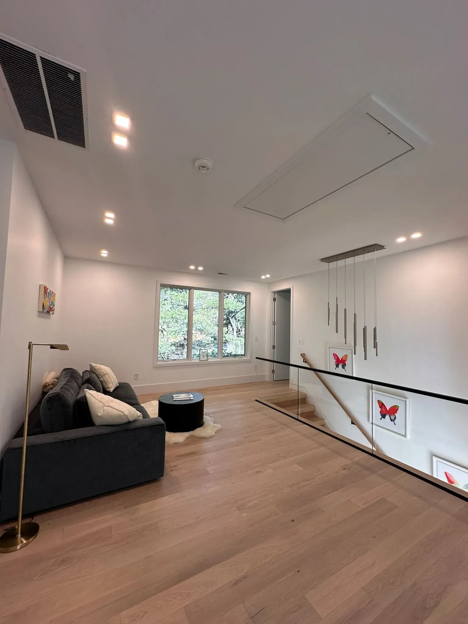 Upstairs loft with recessed lights and a pendant cluster