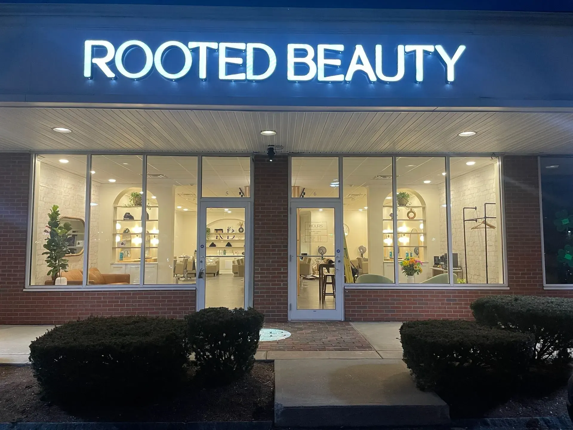Salon storefront with an illuminated channel-letter sign at dusk