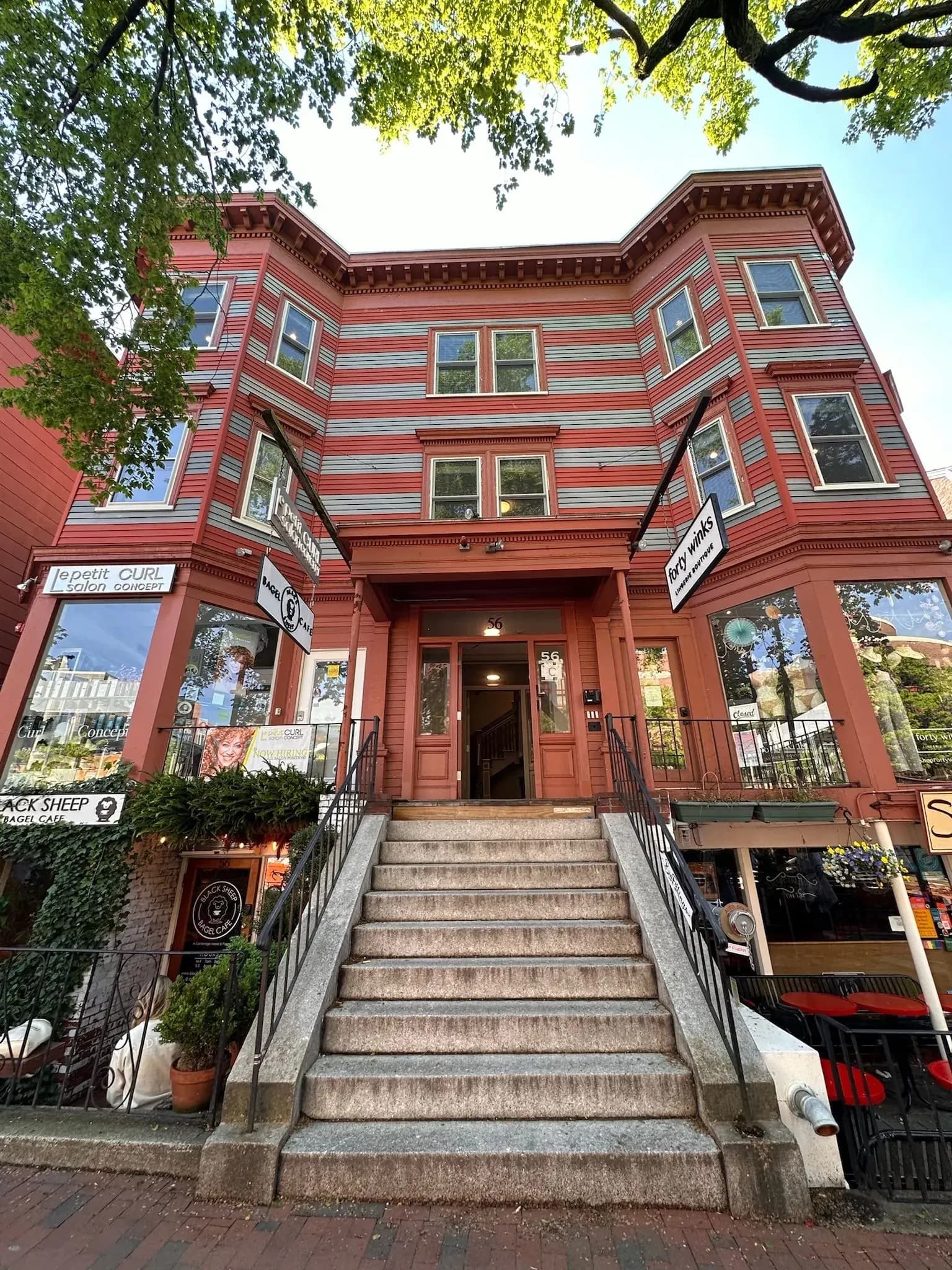 Victorian brick mixed-use building with a lit entry