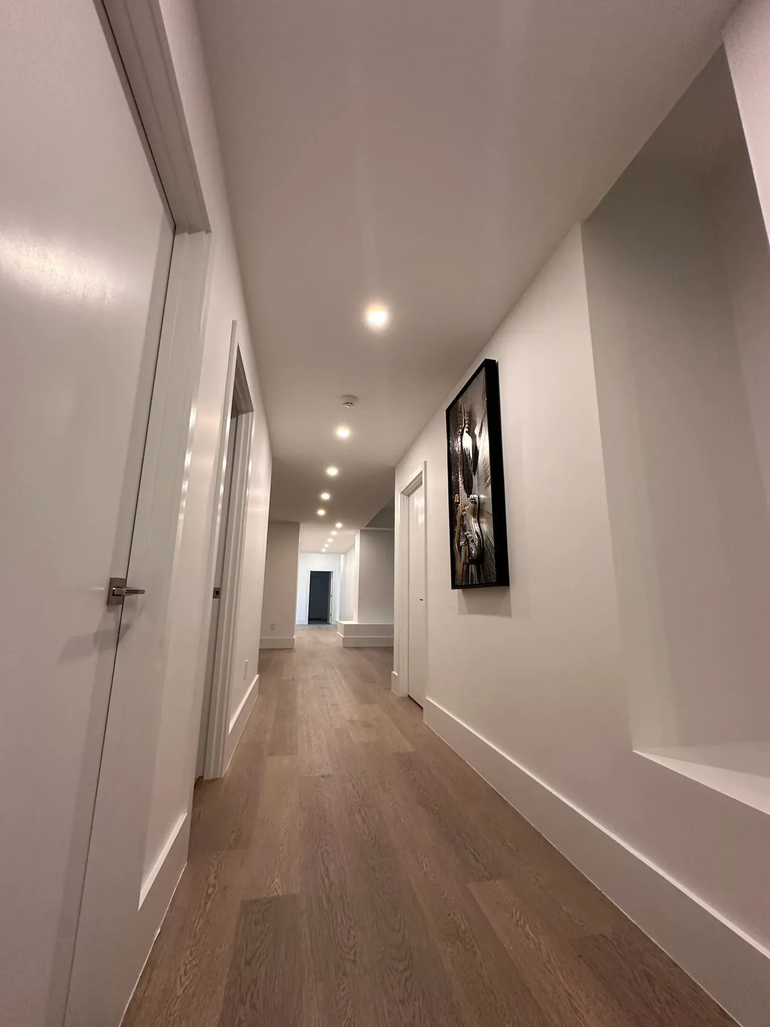 Long hallway lit by a row of recessed lights