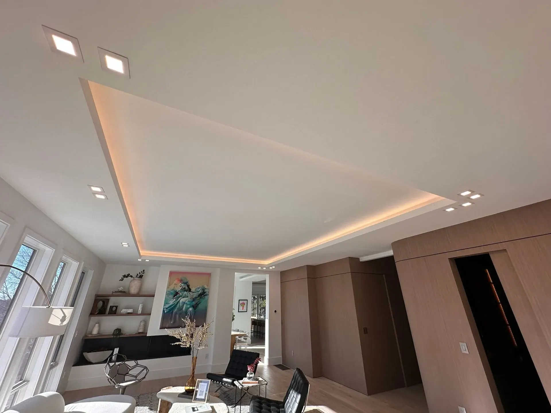 Living room tray ceiling with a warm LED cove and square recessed lights