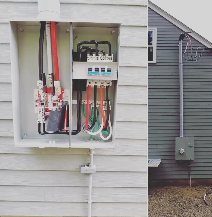 Opened exterior disconnect with new conductors landed, mounted on house siding